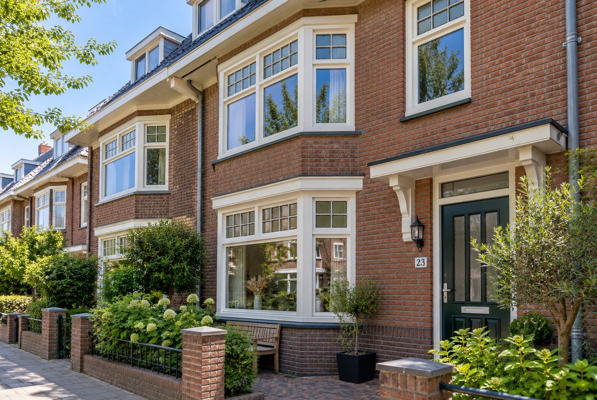 Witte kunststof kozijnen met roedeverdeling in de erkers en ramen van een karakteristieke Nederlandse jaren 30-woning